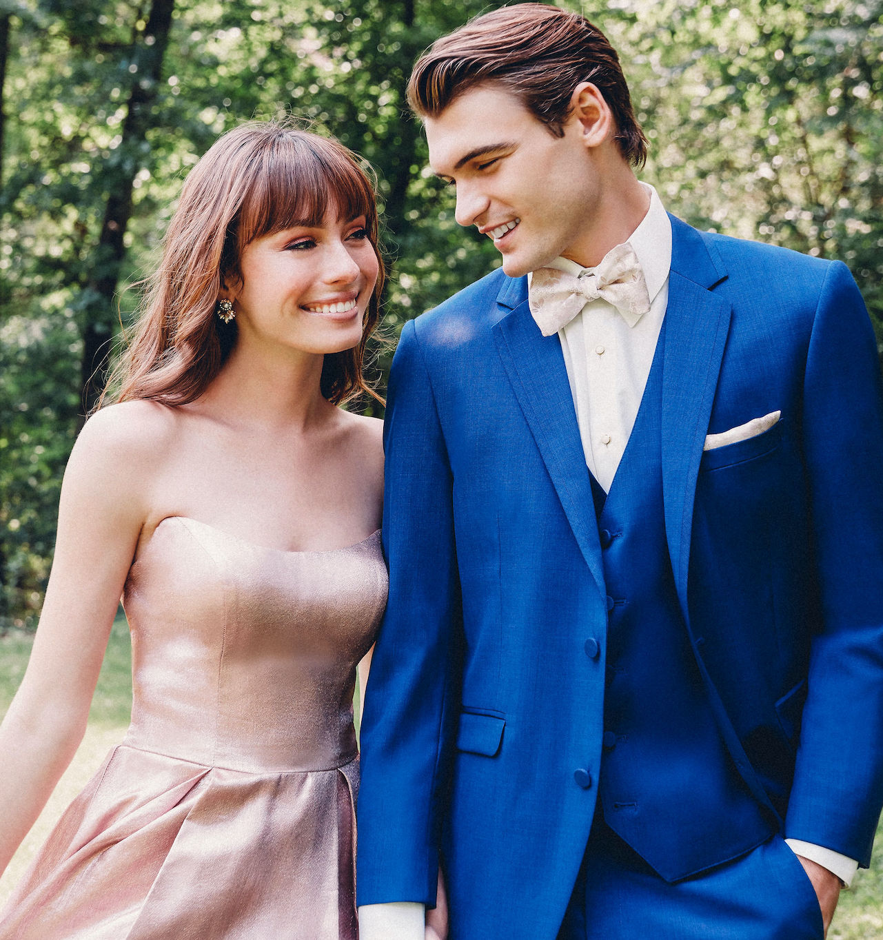 Сouple wearing a pink gown and a blue suit. Mobile image
